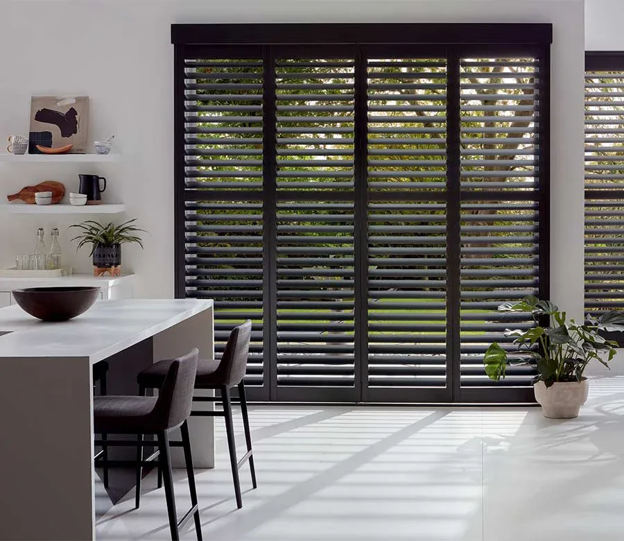 Dark Kitchen Shutters, Matte charcoal plantation shutters on a wide kitchen opening, louvers open to the backyard. By Custom Fabric Creations, St. Petersburg, FL.